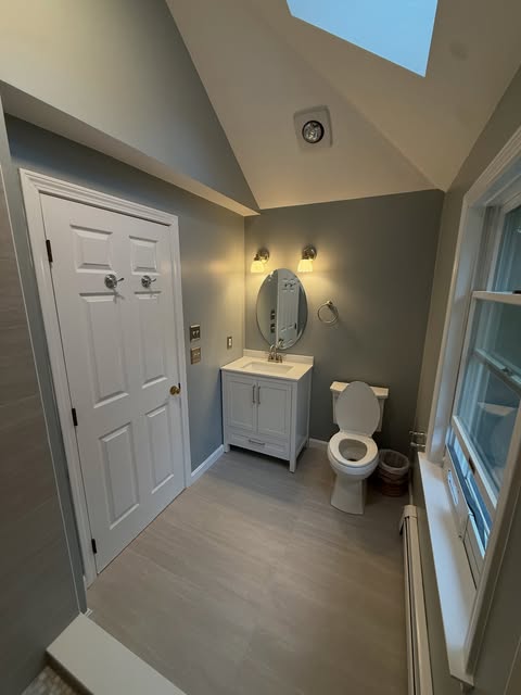 Bathroom with gray painted walls, white trim and finished flooring